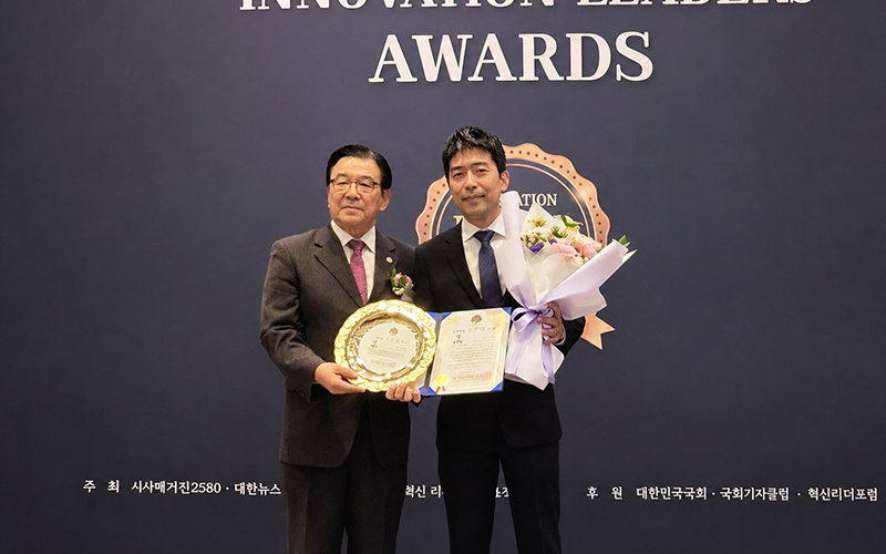 2025 혁신리더 올해를 빛낸 인물대상 시상식에서 수상 명패와 인증서, 꽃다발을 들고 있는 대표원장의 수상 기념 사진