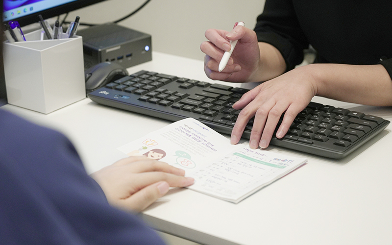 전담 상담사가 체중 관리 브로슈어를 보며 상담을 진행하는 이미지